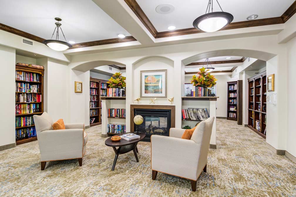 The library at Cottonwood Estates with shelves of books and comfortable seating